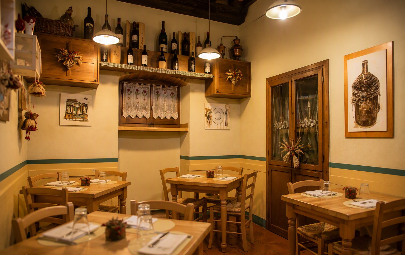 La seconda sala con i tavoli in legno chiaro e le lampade calde